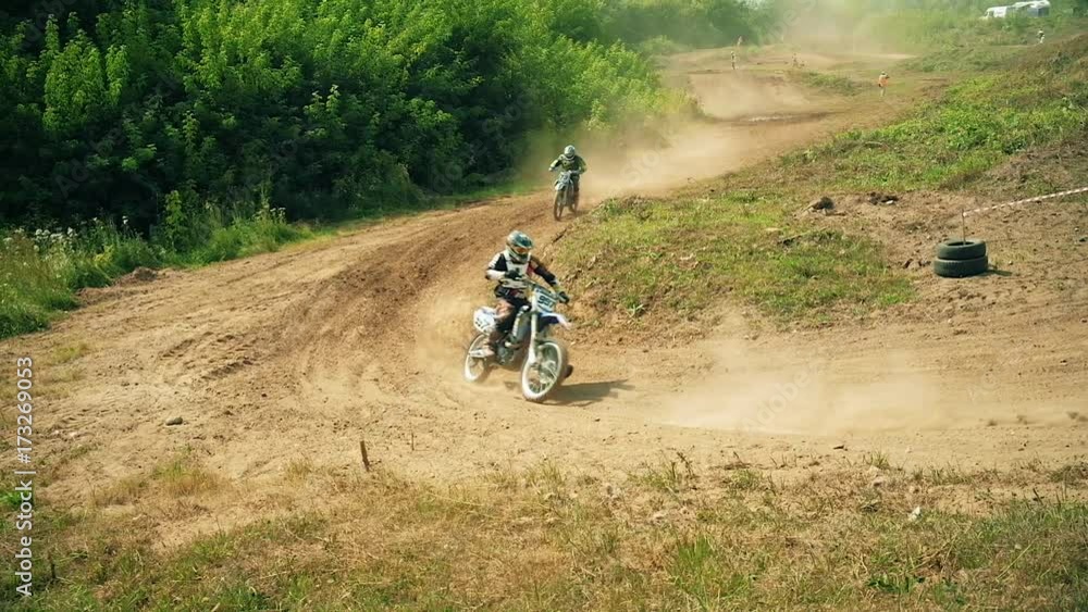 Racing on motorcycles, jumping on a dusty road Racing on motorcycles, jumping on a dusty road