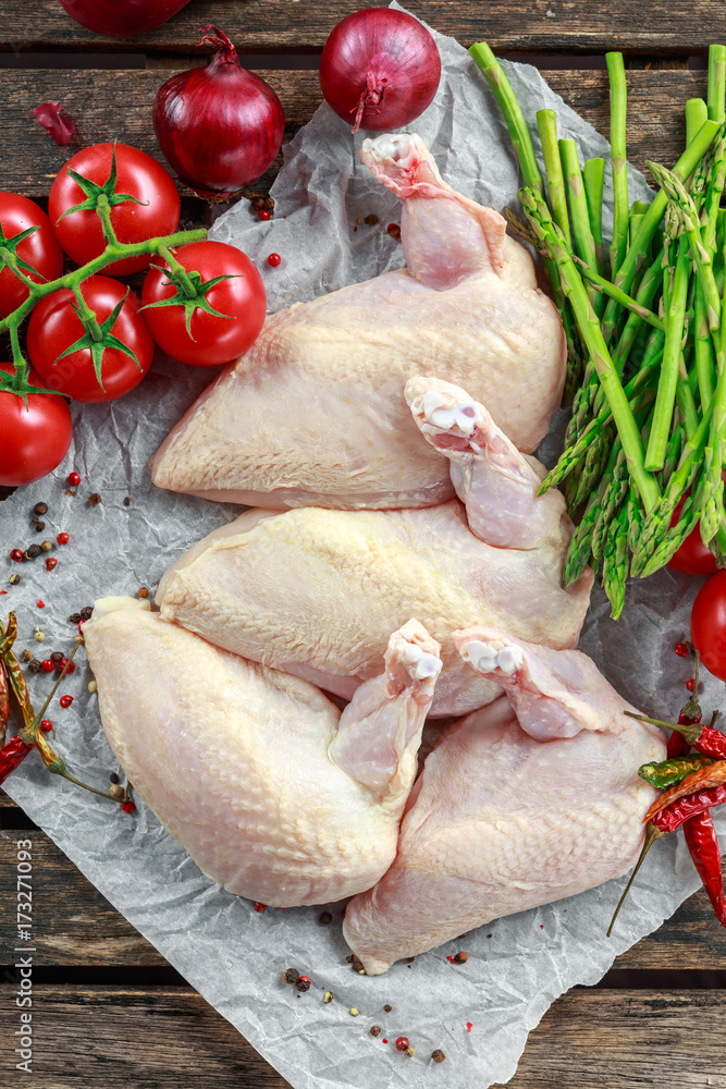 Raw Chicken breast supremes fillets with chilli, pepper corns and thyme. With asparagus and tomatoes for side dish Raw Chicken breast supremes fillets with chilli, pepper corns and thyme. With asparagus and tomatoes for side dish
