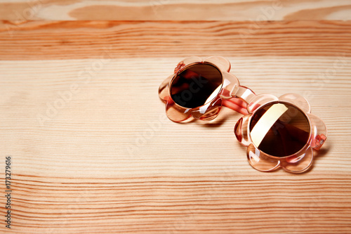 Girl's sunglasses on wooden background
