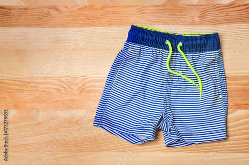 Принти на полотні Boy's swimming trunks on wooden background