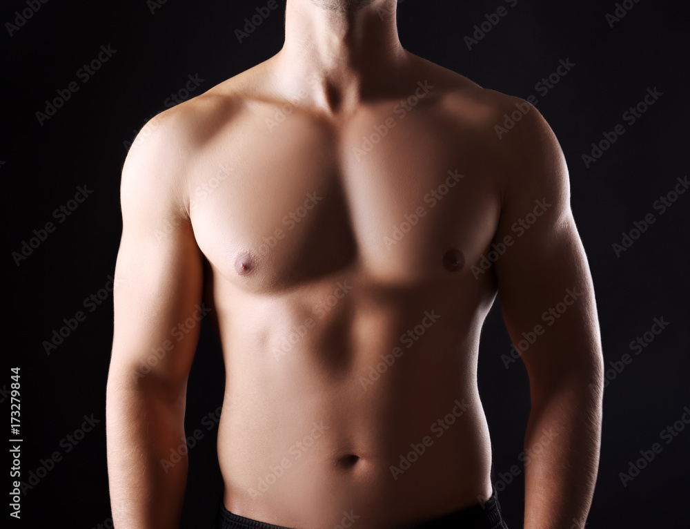 Naklejka premium Sporty young man on dark background