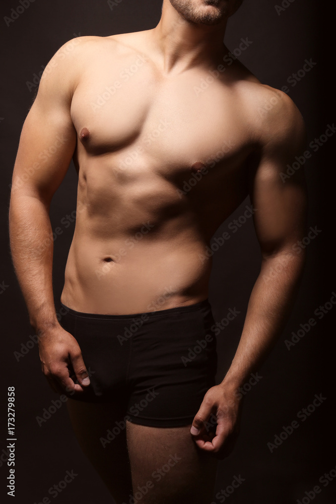 Fototapeta premium Sporty young man on dark background