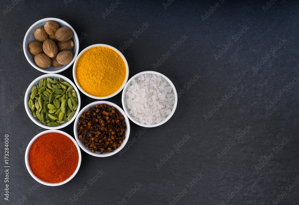 A variety of exotic spices in ceramic bowls top view A variety of exotic spices in ceramic bowls top view