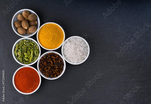 A variety of exotic spices in ceramic bowls top view