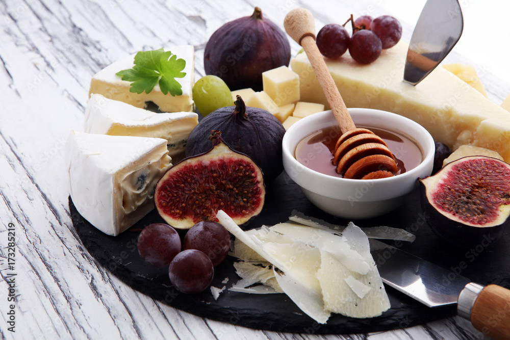 Cheese plate served with grapes, figs and honey