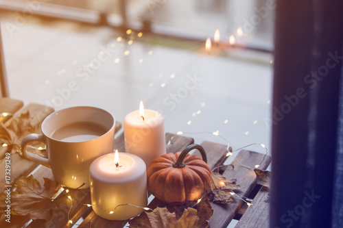 cup of coffee or tea near a pumpkin and candles