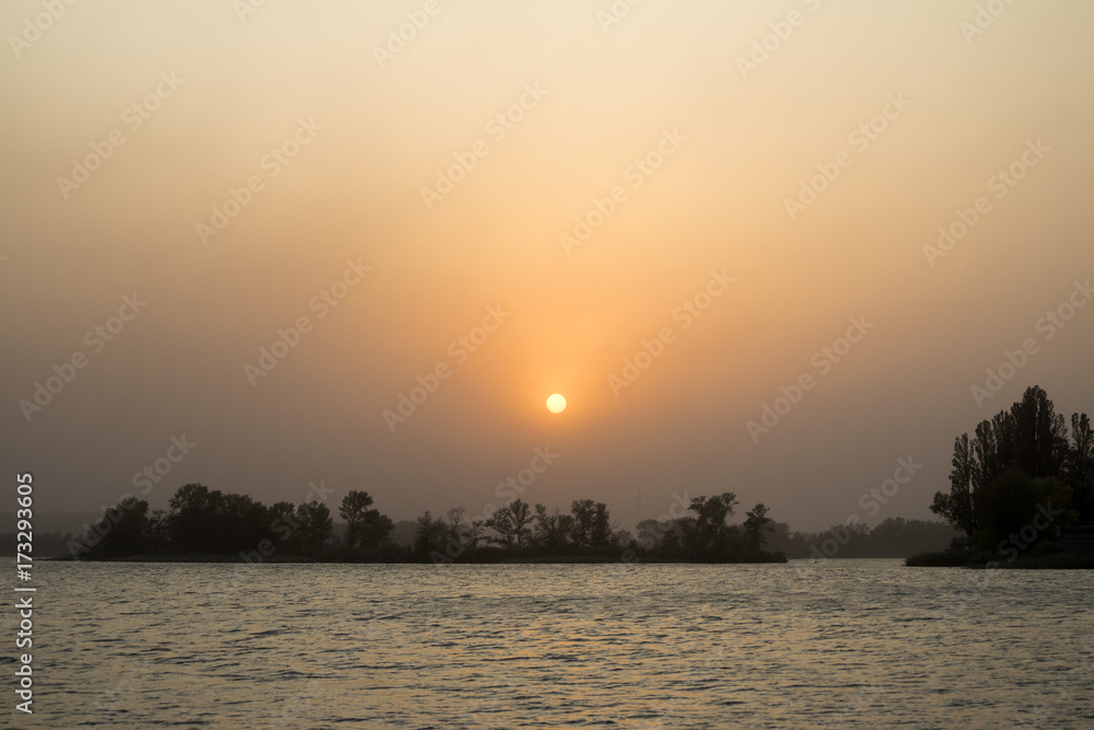 Obraz premium Sunset on the coast of the river in summer
