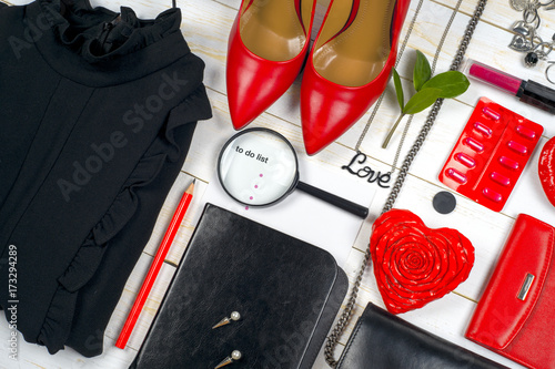 Women clothing set and accessories on white wooden background.