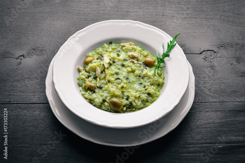 Risotto with spinach, cheese and olives. On a wooden background. Top view. Free space.