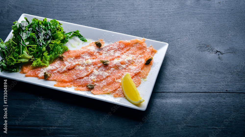 Carpaccio of salmon. On a wooden background. Top view. Free space. Carpaccio of salmon. On a wooden background. Top view. Free space.