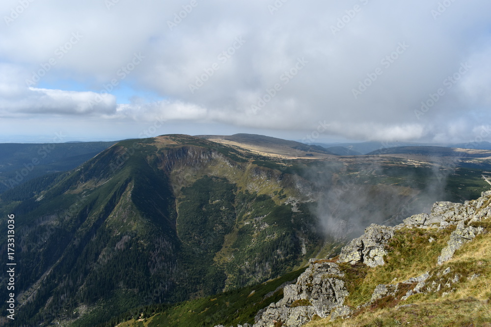 Panoramic View of Mountains with Meadow, Blue Sky and Clouds Panoramic View of Mountains with Meadow, Blue Sky and Clouds