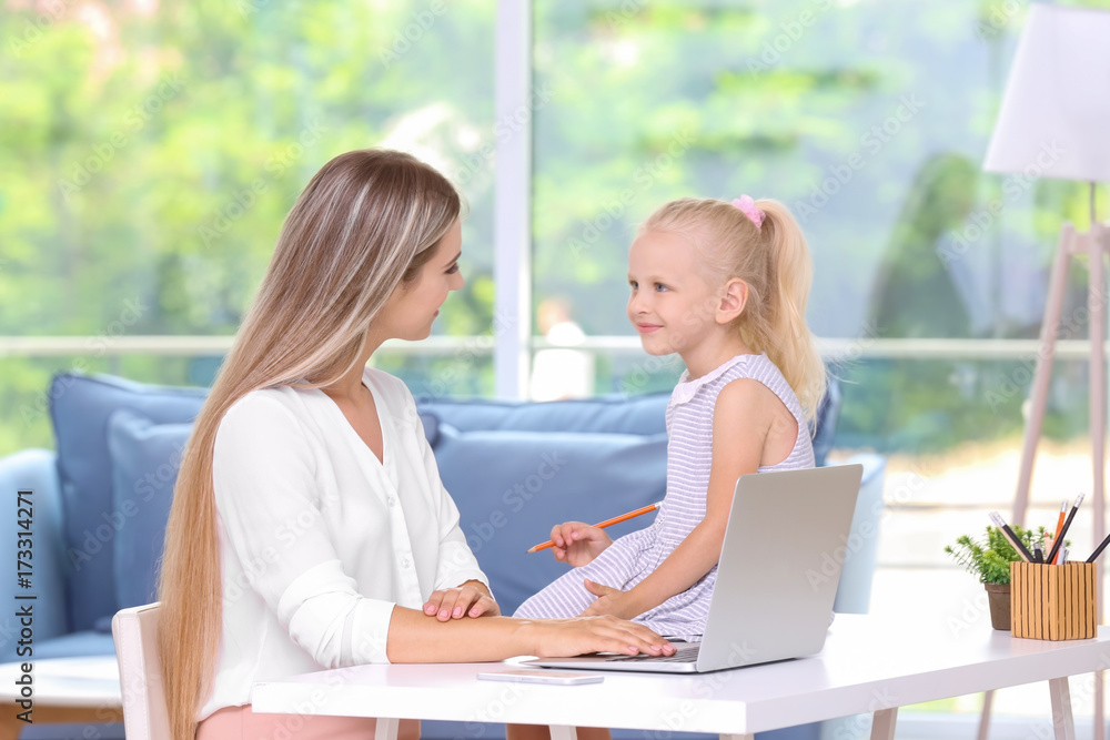 Busy young woman with her daughter at home Busy young woman with her daughter at home