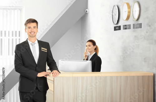 Male receptionist working i...