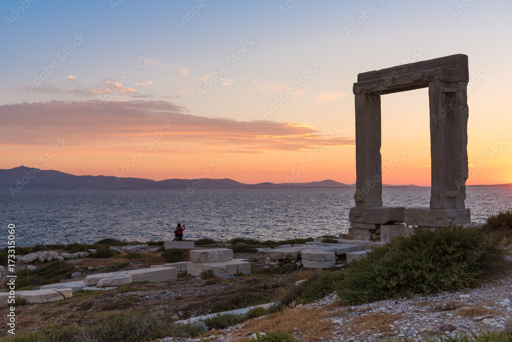 The Portara, one of Naxos island most famous landmarks with overlooking the sunset. Cyclades Islands, Greece. 