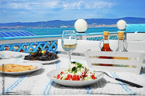 Fototapeta Naklejka Na Ścianę i Meble -  Plates with exotic salad, flatbread and mussels on table in open air restaurant