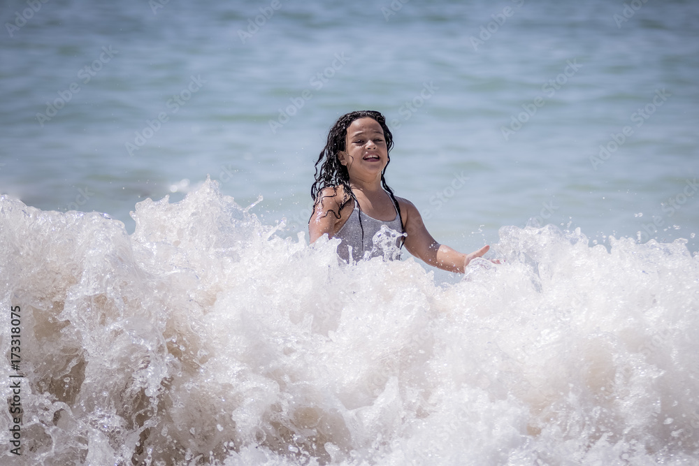 Niña morena bañándose en el mar y jugando con las olas. Niña morena bañándose en el mar y jugando con las olas.