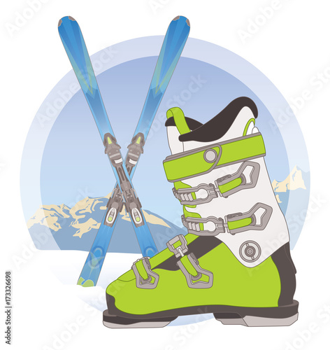 ski boot and pair of skis crossed on snow with mountains in the background