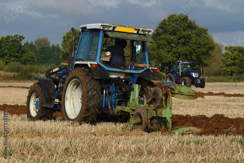blue tractor ploughing a field