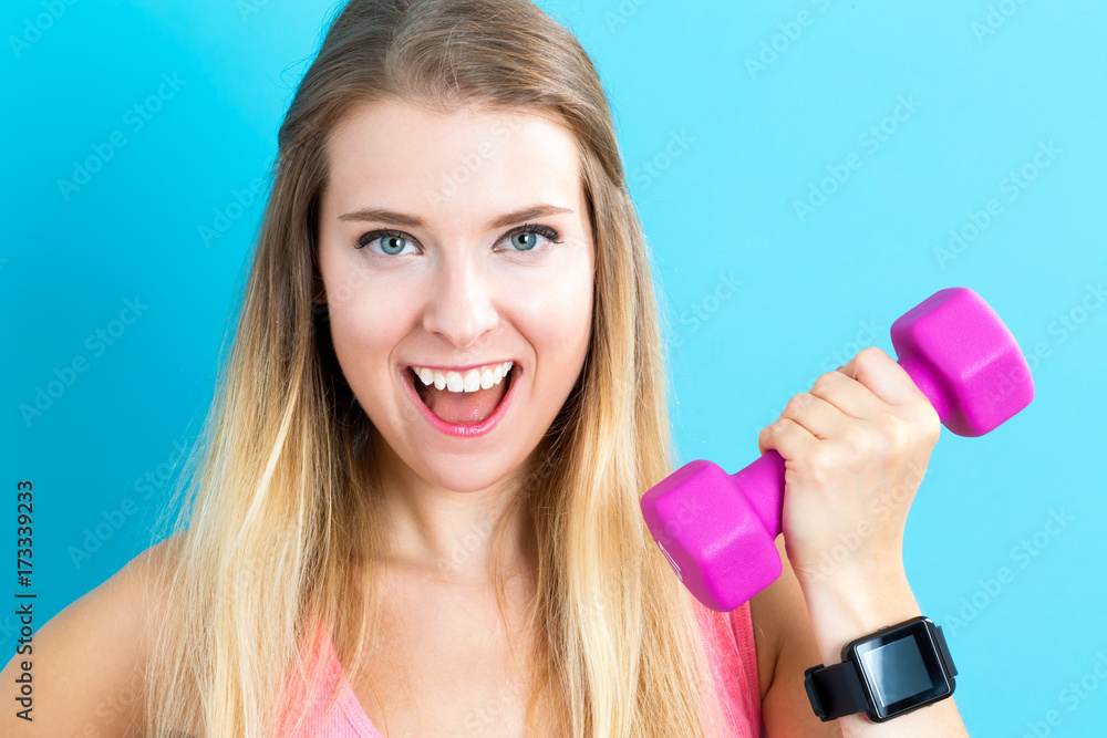 Happy young woman working out with dumbbell Happy young woman working out with dumbbell