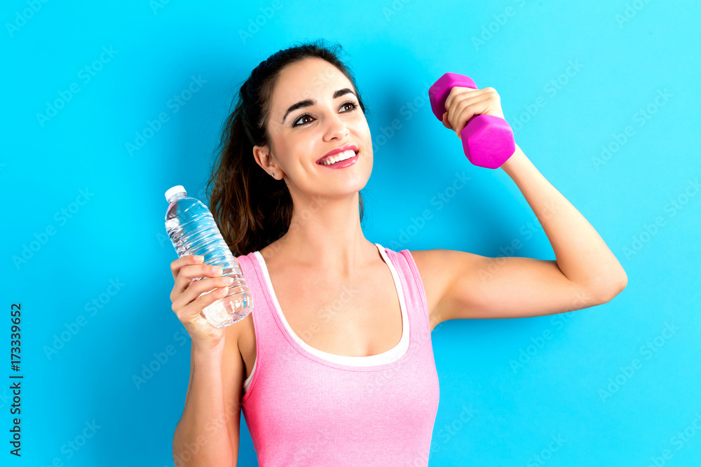 Happy young woman holding an apple and a water bottle Happy young woman holding an apple and a water bottle