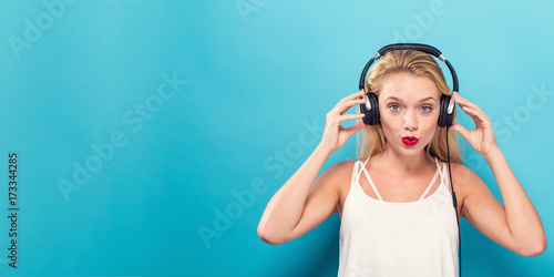 Happy young woman with headphones on a solid background