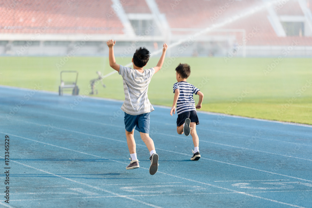 Fototapeta premium Boy running on the blue track