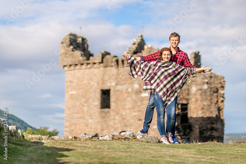 Couple at Urquhart castle in summer evening, Scotland photo