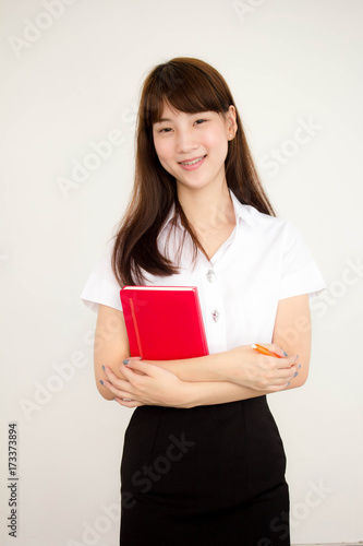 Portrait of thai adult student university uniform beautiful girl read red book