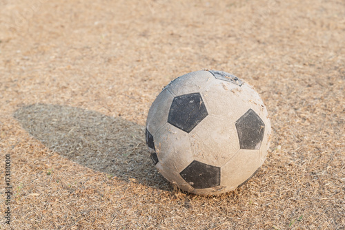 Old football on dried grass