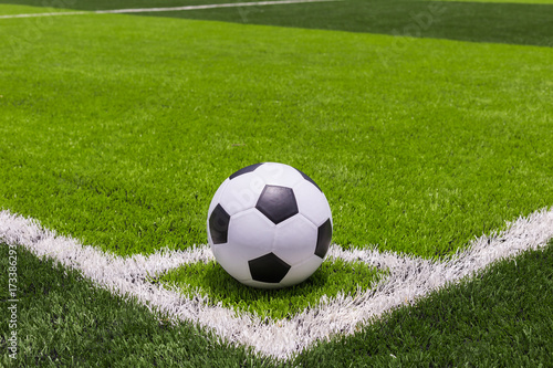 Soccer ball on artificial bright and dark green grass at public outdoor football or futsal stadium © SKT Studio