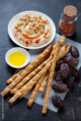 Grissini, date fruits and hummus, selective focus, vertical shot