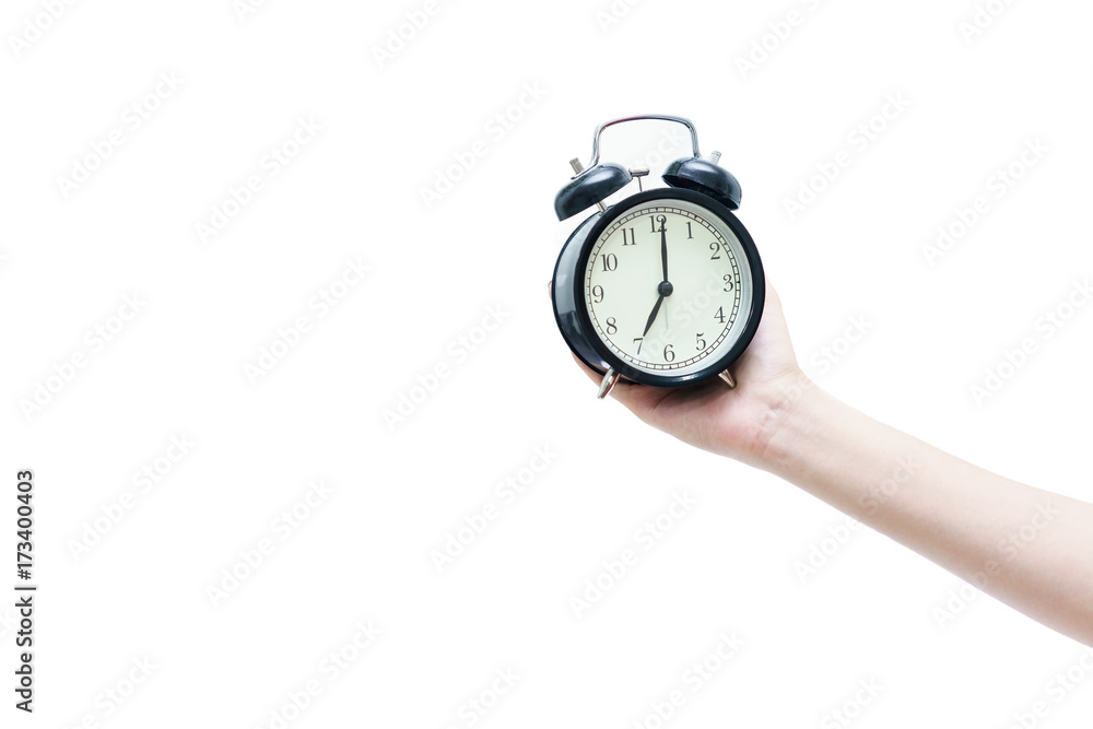 Woman's hand holding black traditional wind-up (keywound), mechanical, spring-driven alarm clock isolated on white background Woman's hand holding black traditional wind-up (keywound), mechanical, spring-driven alarm clock isolated on white background