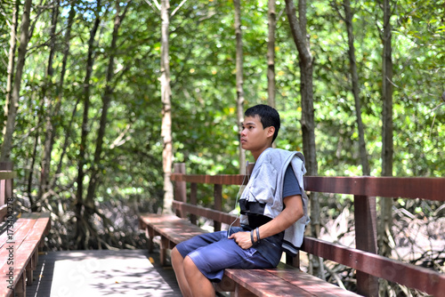 The boy travel alone through mangrove forest at Ra yong,Thailand.The boy's left wrist wrote: May I serve the king forever. photo