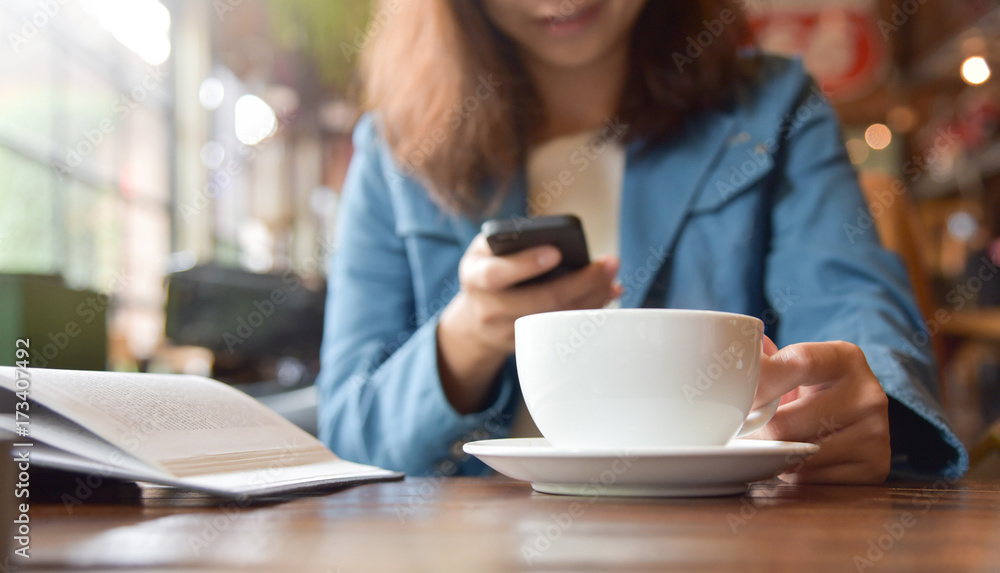 Woman Hands holding cup of coffee and using smart phone. Woman Hands holding cup of coffee and using smart phone.