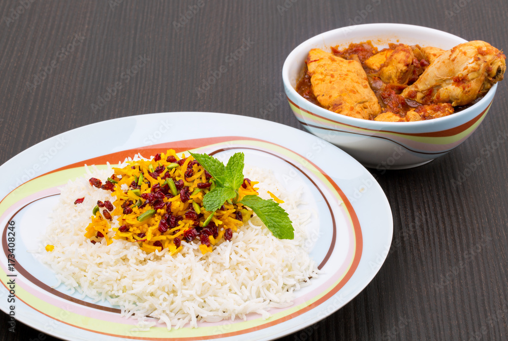 Rice Pilafs Known As Zereshk Polo a Persian Iranian Dish Topped With Saffron Rice Barberries And Pistachio Served With Flavoring Chicken Meat In Tomato Sauce On Wooden Table Rice Pilafs Known As Zereshk Polo a Persian Iranian Dish Topped With Saffron Rice Barberries And Pistachio Served With Flavoring Chicken Meat In Tomato Sauce On Wooden Table