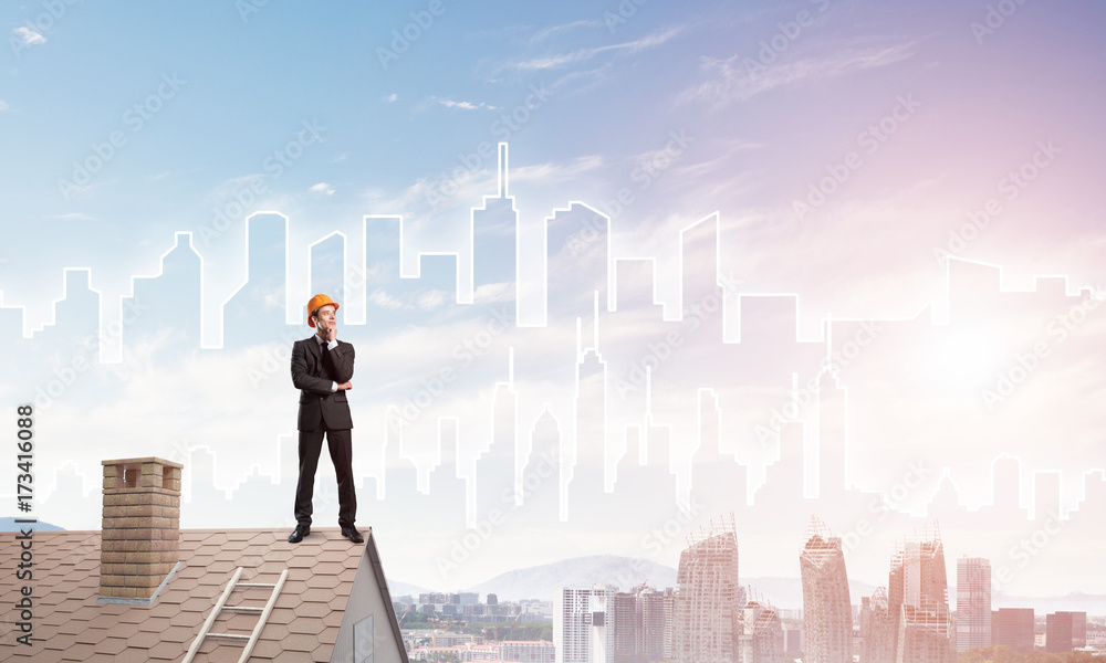 Engineer man standing on roof and looking away. Mixed media Engineer man standing on roof and looking away. Mixed media