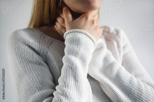 Sore throat of woman.Touching the neck photo