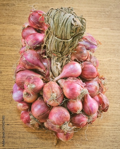 Bunch of Fresh Red Onions on Wooden Table