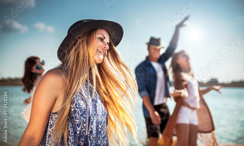 Group of friends dancing and celebrating on beach, boho party © leszekglasner