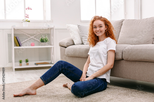Young redhead woman sitting on the floor