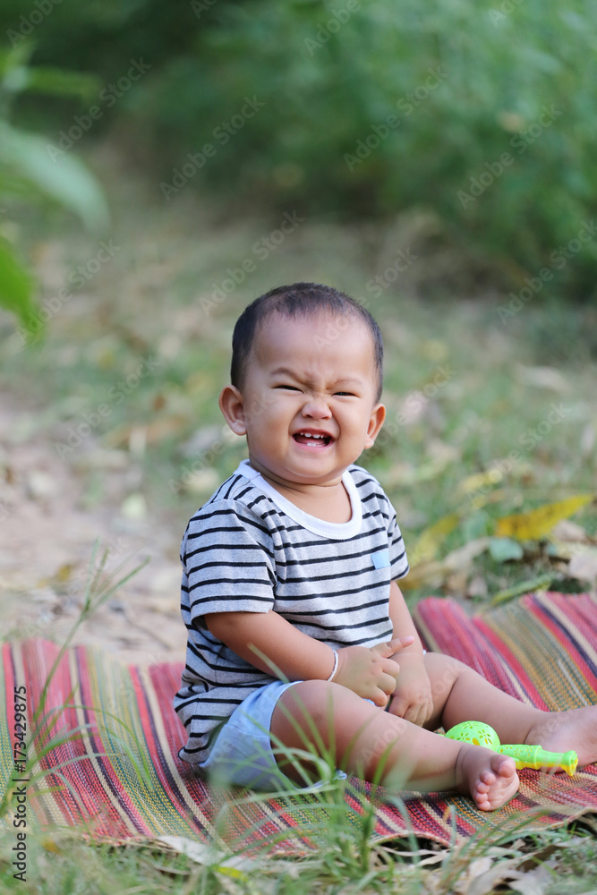 Asian child boy sit on Thai mat in the garden. Asian child boy sit on Thai mat in the garden.