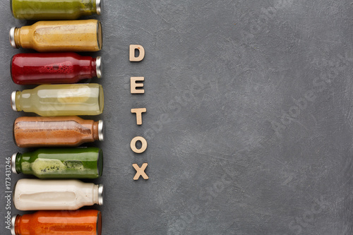 Assortment of detox smoothies in glass bottles on gray background. photo