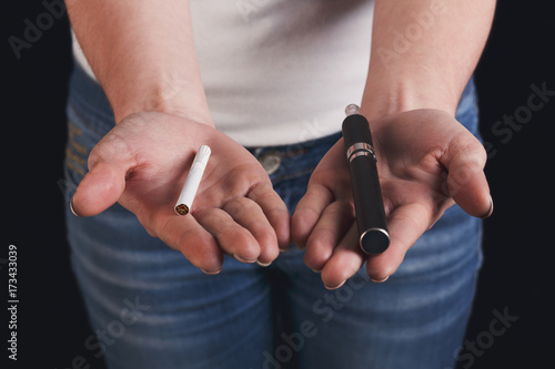 Woman offers a choice between tobacco cigarette and electronic cigarette