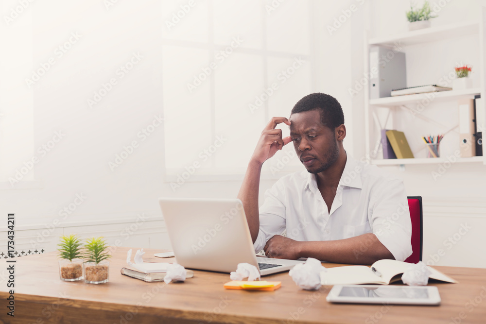 Tired african-american employee in office, work with laptop Tired african-american employee in office, work with laptop