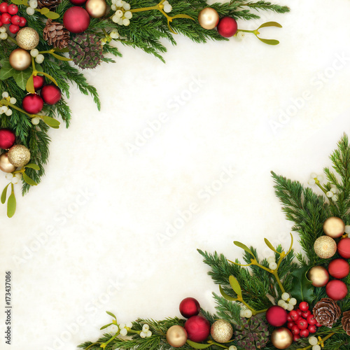 Decorative christmas background border with red and gold bauble decorations  holly  mistletoe  ivy  juniper fir and pine cones on old parchment paper.
