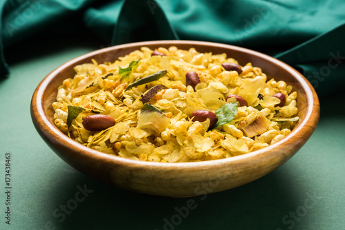 Indian traditional and popular snack poha chivda or chivada made from frying items like thin flattened rice, red chili, curry leaves, groundnuts, cashew nuts and almonds. selective focus
