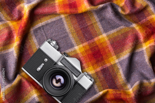 Old retro camera on warm coverlet or bedspread with copy space for your promotional text or advetrisment Cozy domestic atmosphere. Photography conept. Top view of old device. photo