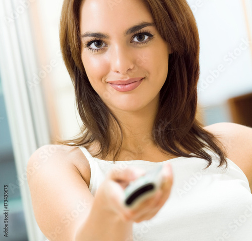 Smiling woman watching TV at home