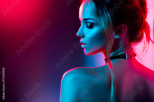 Beautiful sexy girl with trendy make-up in colorful bright lights