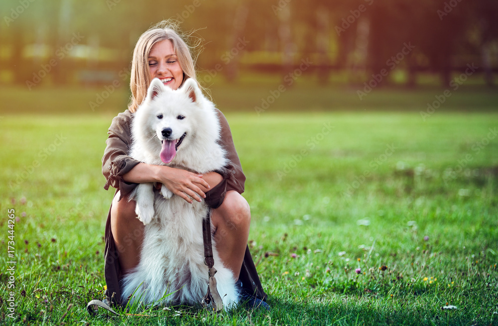 Pretty girl playing with her dog in the park, samoyed Pretty girl playing with her dog in the park, samoyed